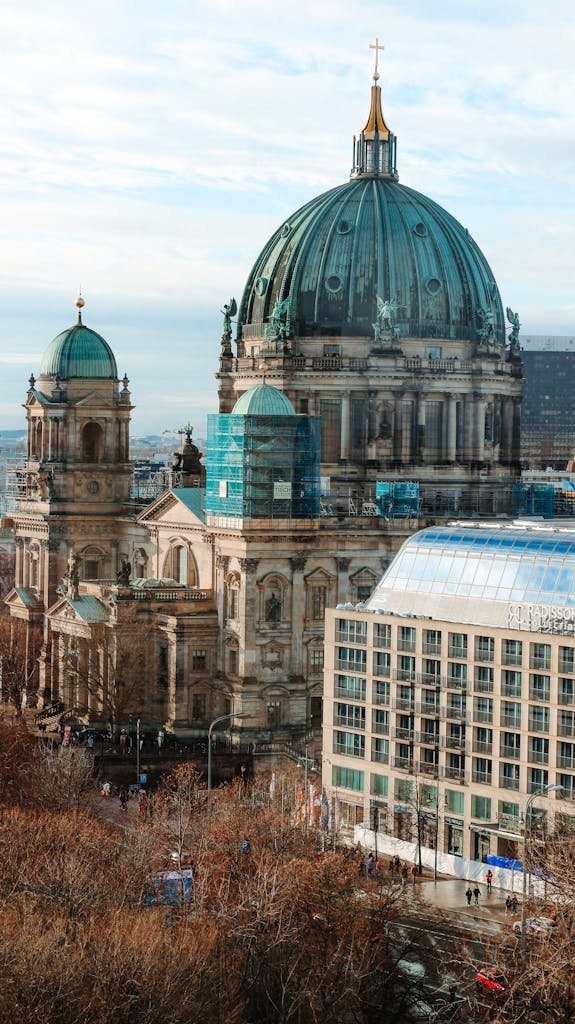 A stunning aerial view of Berlin Cathedral surrounded by autumn foliage, capturing historical architecture.