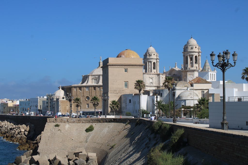 Experience the majestic Cádiz Cathedral by the ocean on a sunny day.