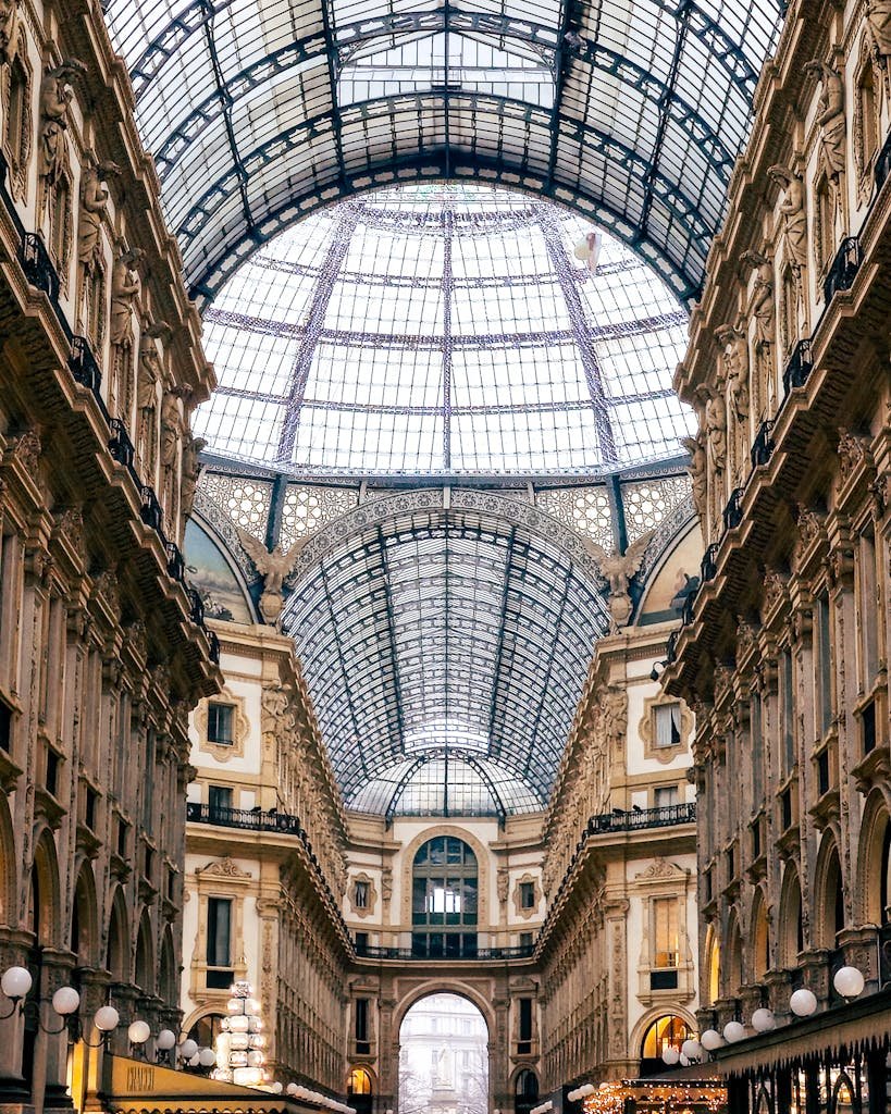 Stunning interior view of Galleria Vittorio Emanuele II, Milan, showcasing its iconic glass dome and historic architecture.