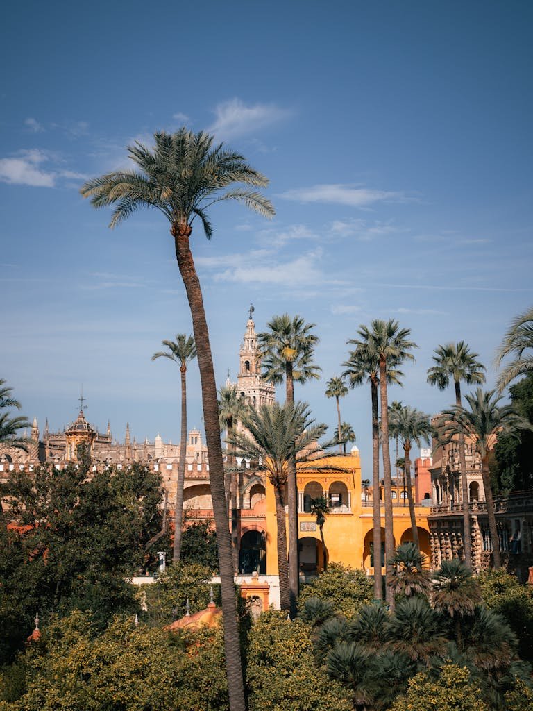 Alcázar de Sevilla con palmeras por delante.