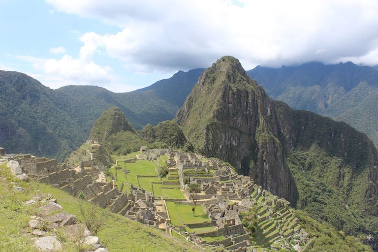 Breathtaking aerial view of Machu Picchu, Peru, showcasing the iconic Inca ruins against lush mountains.