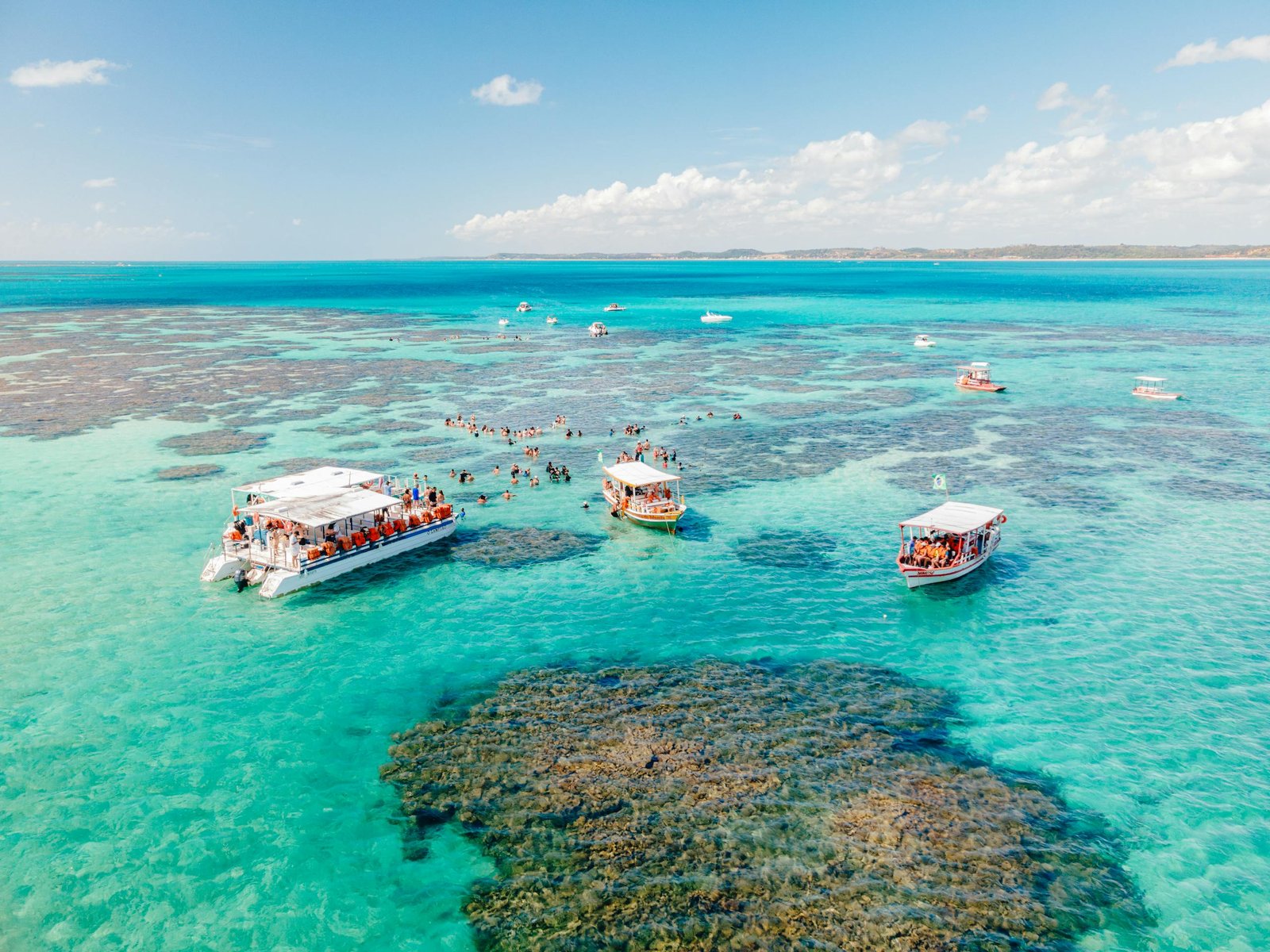 Discover the stunning turquoise tide pools of Maragogi, Brazil, under a clear blue sky.