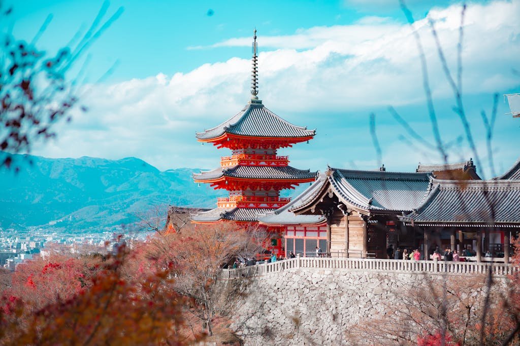 Stunning view of Kiyomizu-dera Temple in Kyoto, surrounded by autumn foliage and cityscape backdrop.